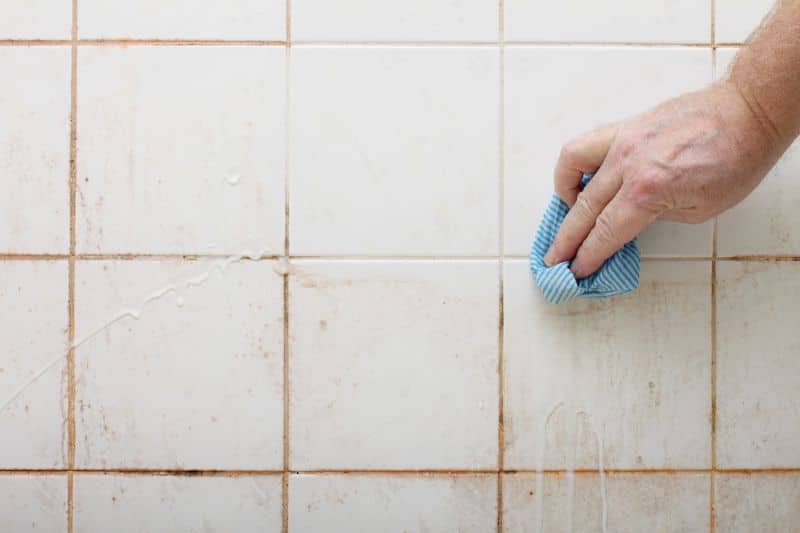 scrubbing tilr wall of the bathroom