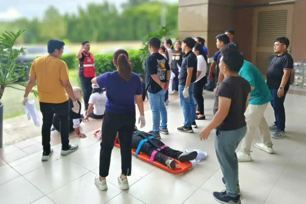 People gathered outside during what appears to be an emergency evacuation or drill.