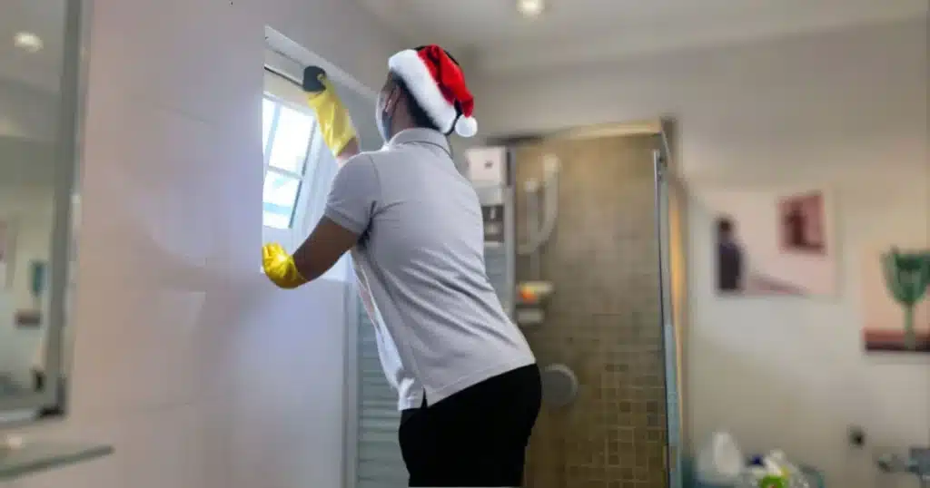 a housekeeping cleaning the window of  the bathroom 