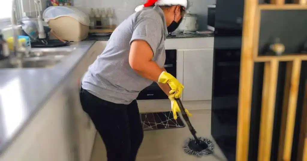 a housekeeping mopping the floor in the kitchen area