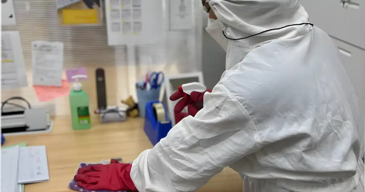 a person cleaning a table/workplace